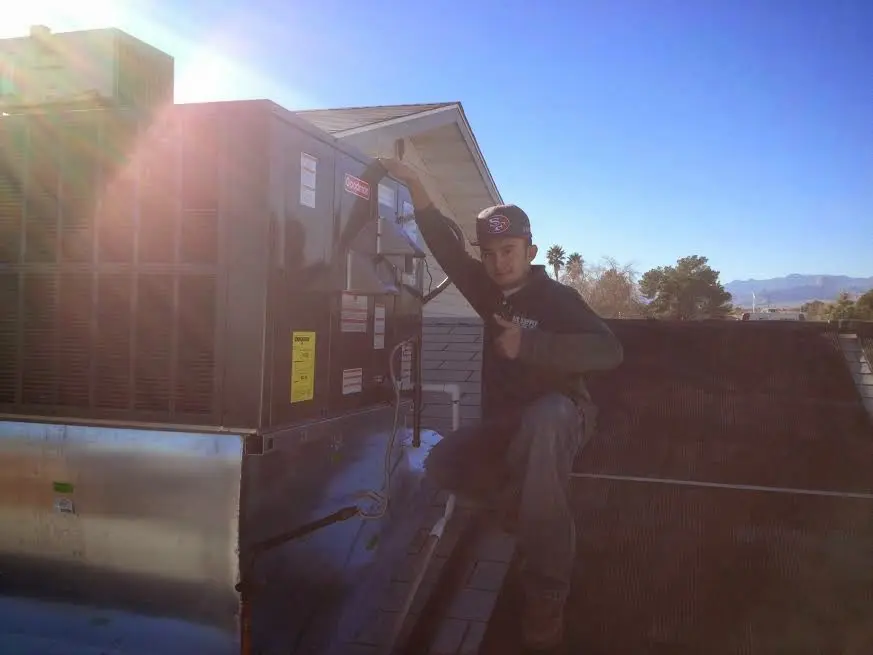 HVAC technician performing Heat Pump Repair on a rooftop unit in Monterey Park